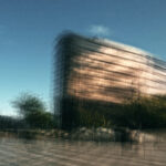 A painterly, multi-layered architectural photograph of an office building. The repetitive lines and glass reflections are blended to create a soft, abstract texture that feels structured and balanced.